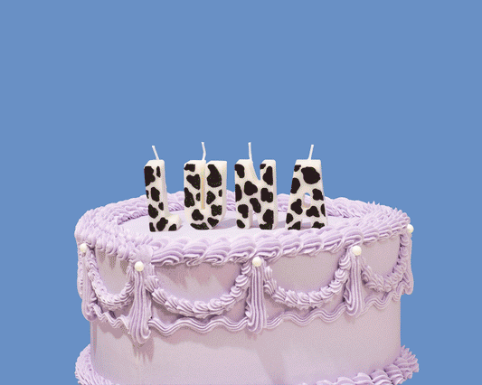 Moving GIF image of an iced purple cake topped with birthday candles that spell out different words and names. The candles are hand painted different colors and fun patterns.